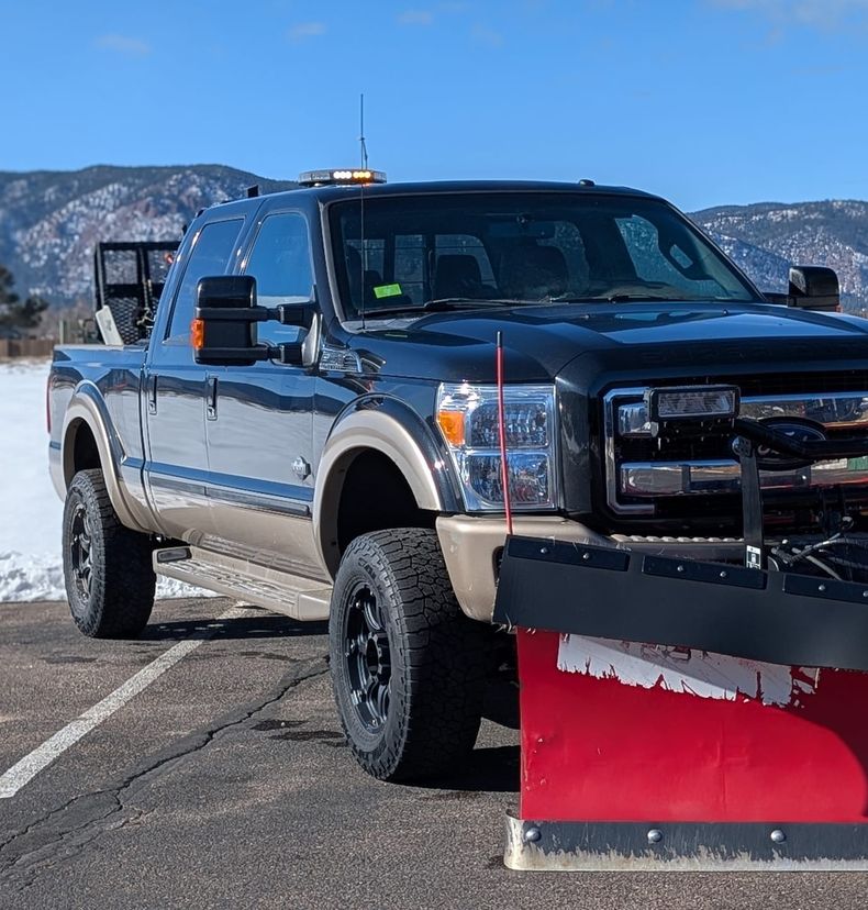 Plow truck with the snowy foothills behind